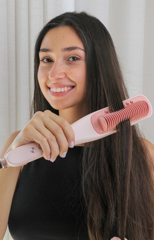Customer smiling while styling long dark hair with the SteamPro