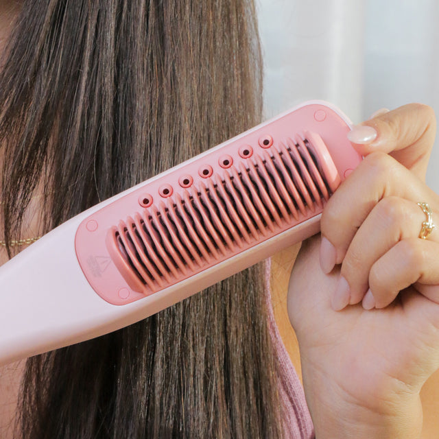 Close-up of the SteamPro comb gliding through long hair